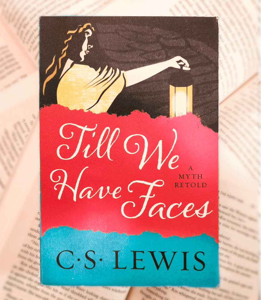 One of the Standalone ya fantasy books by C.S. Lewis called - "Till We Have Faces". Closed cover displayed in front of lots of open books.